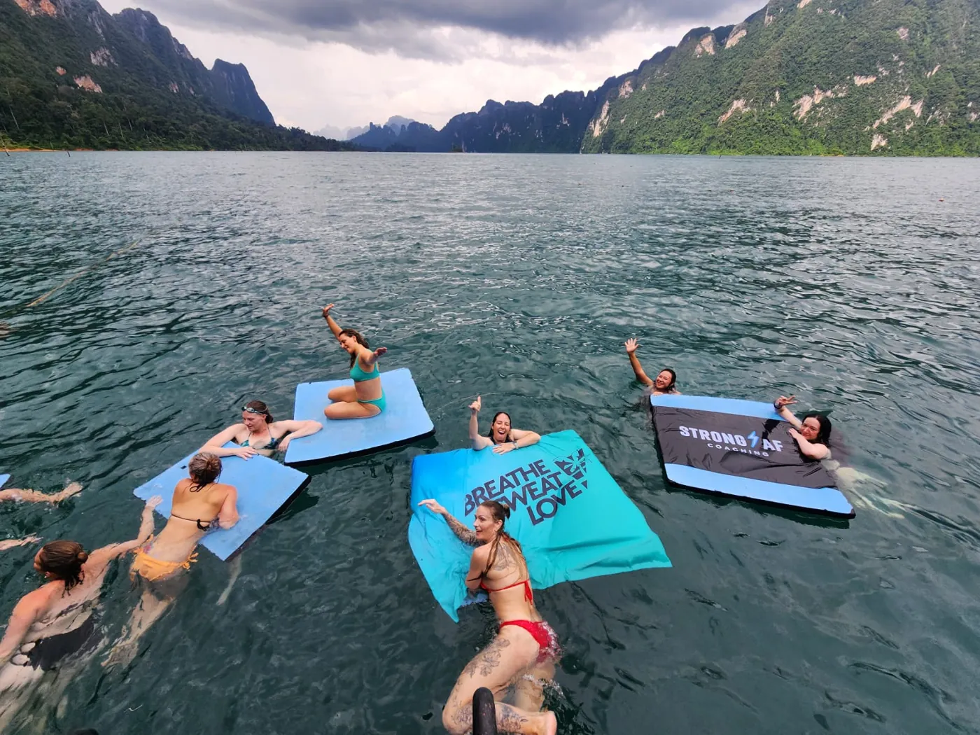 The group swimming with BSL and Strong AF flags on Khao Sok lake